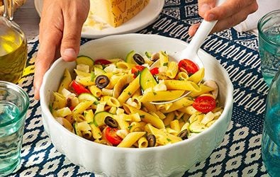 Penne alla crudaiola con pomodorini, zucchine, funghi, olive e Grana Padano