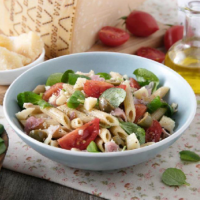 Kalter Nudelsalat mit Tomaten, grünen Oliven, Kochschinken, Feldsalat und Grana Padano