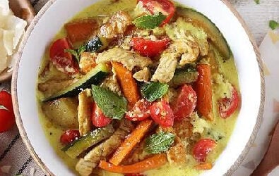 Zuppa tiepida al curry con pollo zucchine, patate, carote, pomodorini e Grana Padano DOP