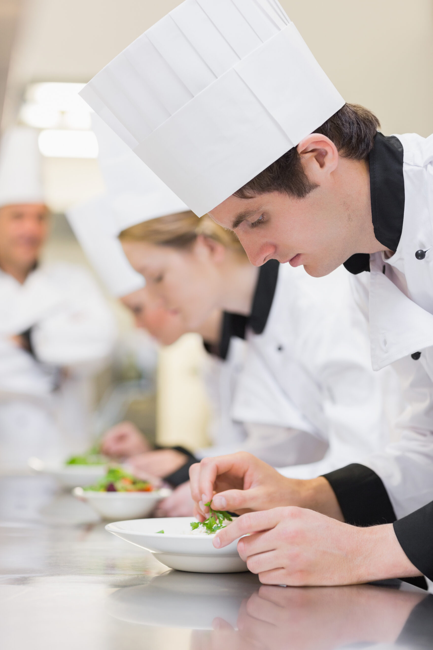 Culinary class making salads with teacher watching over